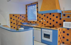 een keuken met blauwe en oranje tegels op de muur bij Pet Friendly Apartment In Talasani With Private Swimming Pool, Can Be Inside Or Outside in Talasani