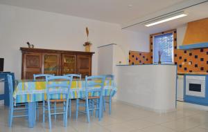 a dining room with a table and blue chairs at Cozy Apartment In Talasani in Talasani