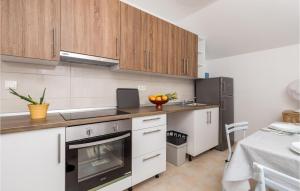 a kitchen with wooden cabinets and a stove top oven at Amazing Apartment In Vlasici With Kitchen in Vlašići