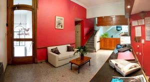 a living room with a couch and a red wall at Hotel del Prado in Buenos Aires
