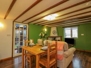 una sala de estar con una mesa y un sofá en Kingfisher Cottage, en Holsworthy