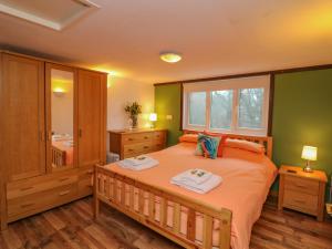 a bedroom with a bed with two towels on it at Kingfisher Cottage in Holsworthy