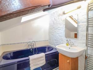 y baño con bañera azul y lavamanos. en Kingfisher Cottage, en Holsworthy 16 fotos más