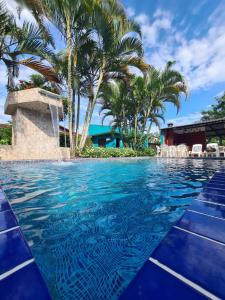 a pool at a resort with palm trees at Pousada Porto do Itagua in Ubatuba