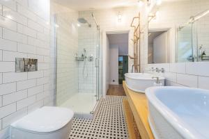 a bathroom with a tub and a toilet and a sink at Dom & House - Apartment Loft Supreme in Sopot