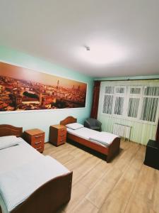 ハンティ・マンシースクにあるДвухкомнатная квартира Энгельса 3 Центрのベッドルーム1室(ベッド2台付)が備わります。壁には絵画が飾られています。