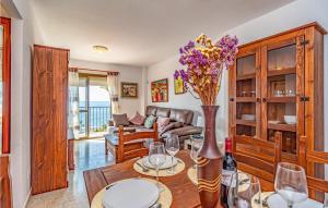 una sala de estar con una mesa con un jarrón de flores en Nice Apartment In Rincn De La Victoria With Wifi en Rincón de la Victoria