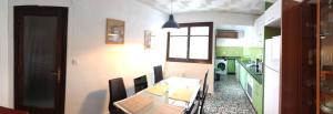 a dining room with a table and a kitchen at Ca Sanchis, piso en el casco antiguo in Xàtiva