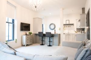 a living room with a couch and a kitchen at Bryan Street Apartments in Ballymena
