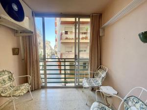 a room with chairs and a balcony with a view at BIG APARTMENT IN THE OLD TOWN in Benidorm