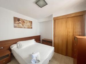 ベニドルムにあるSanta Faz Apartmentのベッドルーム1室(ベッド1台付)が備わります。壁には絵画が飾られています。
