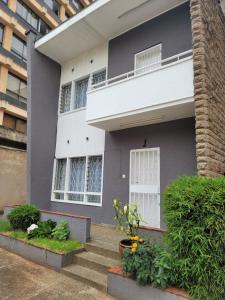 uma casa cinzenta com uma janela branca e escadas em Juke's Serene Westlands Villa em Nairobi