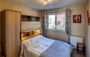 a bedroom with a bed and a window at Nice Home In Riec Sur Belon With 3 Bedrooms in Riec-sur-Bélon