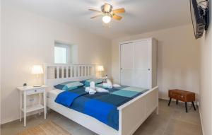 a bedroom with a bed with blue sheets and a ceiling fan at Cozy Home In Lovran With Wifi in Lovran