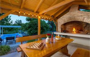 a patio with a table with a chess board and a fireplace at Cozy Home In Lovran With Wifi in Lovran +47 photos
