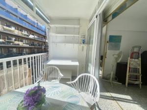 un balcón con mesa, 2 sillas y estanterías en Calle Gambo Apartment, en Benidorm