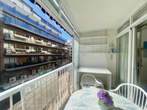 balcón con mesa y sillas y biblioteca en Calle Gambo Apartment, en Benidorm
