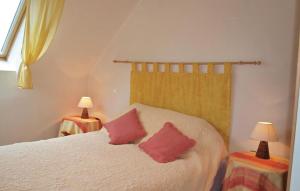 a bedroom with a bed with two red pillows on it at Awesome Home In Plestin Les Greves in Plestin-les-Grèves