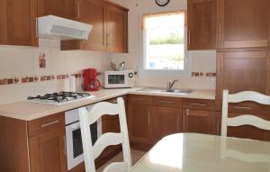 a kitchen with wooden cabinets and a red appliance at Awesome Home In Plestin Les Greves in Plestin-les-Grèves +7 photos