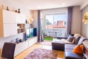 a living room with a couch and a tv at Maria Casa Branca by ALMA Holiday Rentals in Funchal