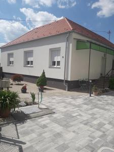 uma casa branca com um telhado e um pátio em Szalay Vendégház em Hegykő