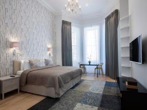 1 dormitorio con 1 cama, TV y mesa en 17 Hertford Street en Londres