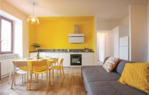 sala de estar con mesa y pared amarilla en Nannina, en Corbara