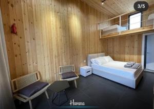 SakësHAVANA HOUSE的一间有一张床和两把椅子的卧室
