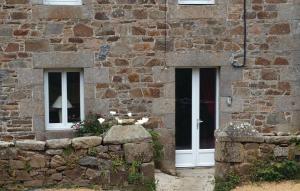 a stone building with a white door and two windows at Stunning Home In Pleumeur Bodou in Pleumeur-Bodou