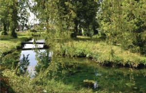 a river with trees and a bridge in a field at Amazing Home In Marconne With Kitchen in Marconne