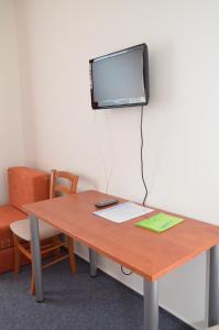 a table with a tv on a wall with a desk at Hotel Růženy in Hustopeče