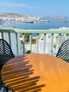 
a wooden bench sitting on top of a beach at Yalos Hotel Sunset view Mykonos town private rooms in Mýkonos City
