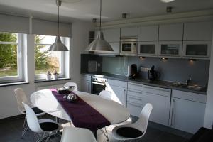 uma cozinha com uma mesa branca e cadeiras brancas em Am Finkenbusch aan de skipiste em Willingen