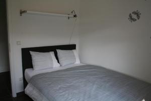 uma cama num quarto com uma parede branca em Am Finkenbusch aan de skipiste em Willingen