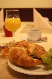 einen Teller mit einem Croissant und Trauben auf einem Tisch in der Unterkunft Hotel Senator in Bielefeld