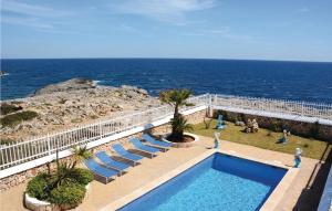 una piscina con sillas y el océano en el fondo en Nice Home In Cala Dor With House Sea View, en Cala d´Or