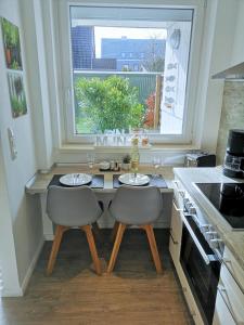 a kitchen with a table with two chairs and a window at Butze Ferienapartment in Büsum