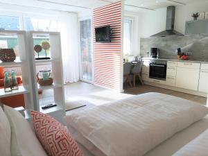 a bedroom with a large bed and a kitchen at Butze Ferienapartment in Büsum