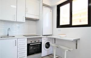 a white kitchen with a washing machine and a sink at Amazing Apartment In Torrevieja in La Mata +9 photos