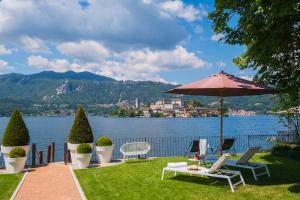 a patio with a table and chairs and an umbrella at Bifora65 flats and garden - Lakeview in Orta San Giulio