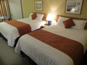 a hotel room with two beds and a lamp at The Nordic Lodge in Sister Bay