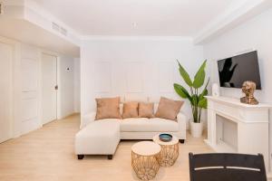 sala de estar blanca con sofá blanco y TV en BHost - The Special One, en Málaga