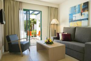 a living room with a couch and a table at Relaxia Lanzasur Club - Aqualava Water Park in Playa Blanca