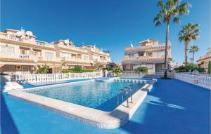 a swimming pool in front of a building with palm trees at Residencia Siesta Sol in Torrevieja