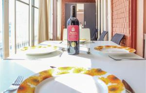 a table with a bottle of wine and a plate of food at Cozy Apartment In Alicante With Wifi in Alicante