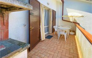 a balcony with a table and chairs and an umbrella at Calabria G41 in Lido di Pomposa +8 photos