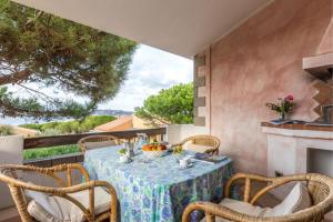 a patio with a table and chairs and a fireplace at Baia Del Faro in Palau
