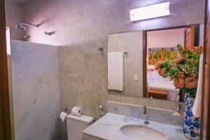 ein Bad mit einem Waschbecken und einem Spiegel in der Unterkunft Pousada Cocoa in Pirangi do Norte