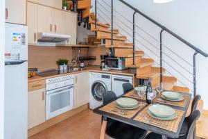 a kitchen with a table and a kitchen with a staircase at The Bubble in La Oliva