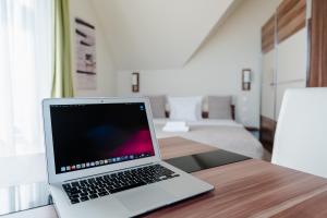 einen Laptop auf einem Holztisch in der Unterkunft B&B Lajta Park in Mosonmagyaróvár